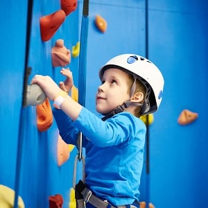 Little boy indoor rock climbing